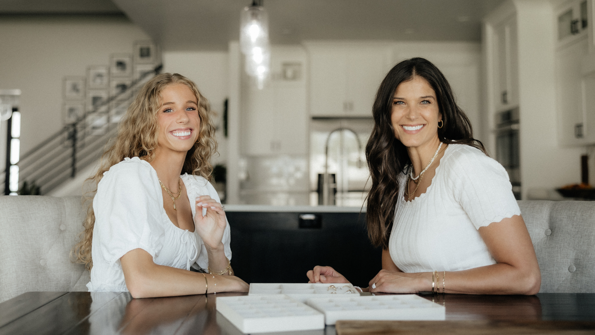 Kim and her daughter McKayla at the kitchen table with trays of jewelry