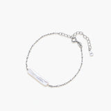 Minimalist bracelet with iridescent baroque pearl on rhodium-plated sterling silver chain against cream background
