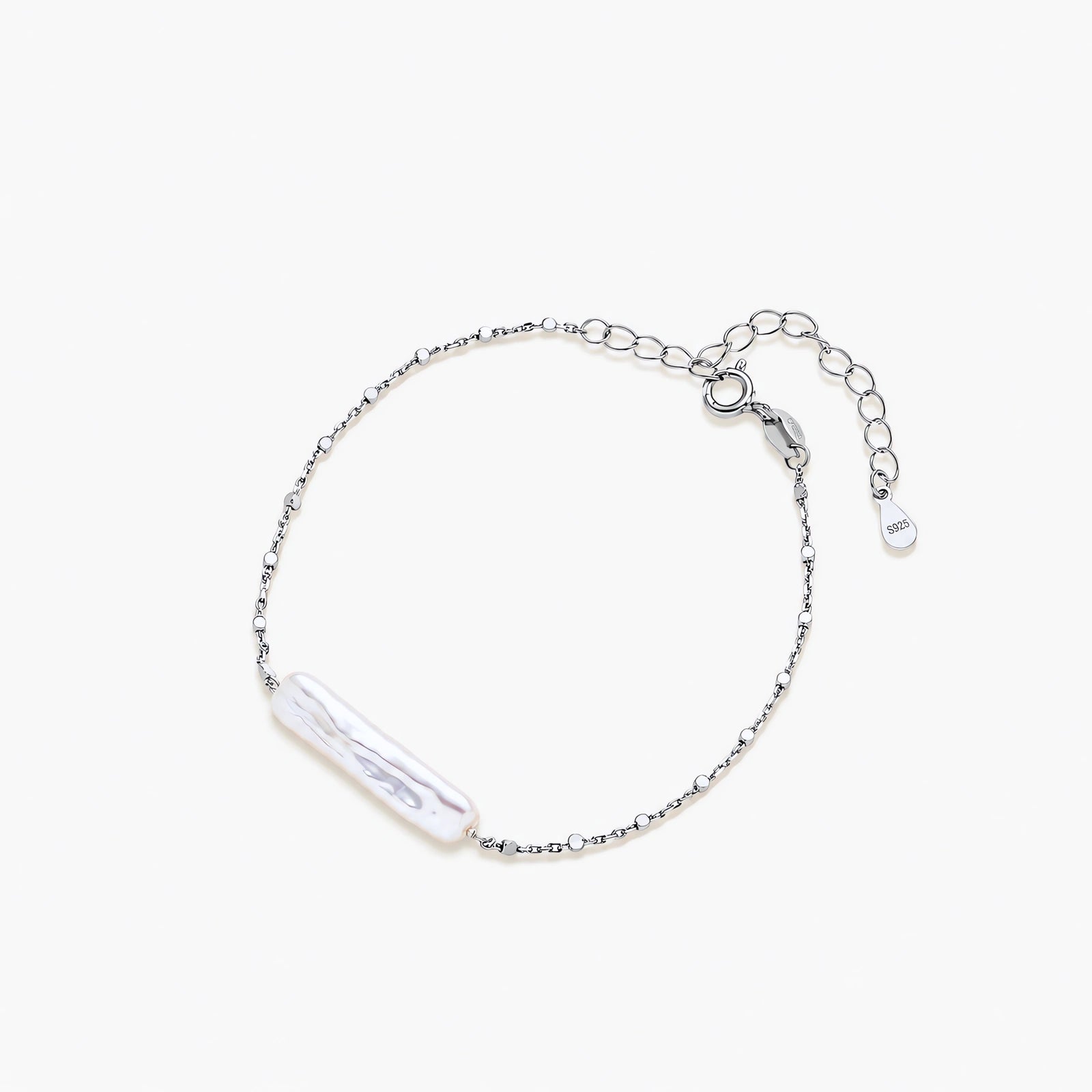 Minimalist bracelet with iridescent baroque pearl on rhodium-plated sterling silver chain against cream background