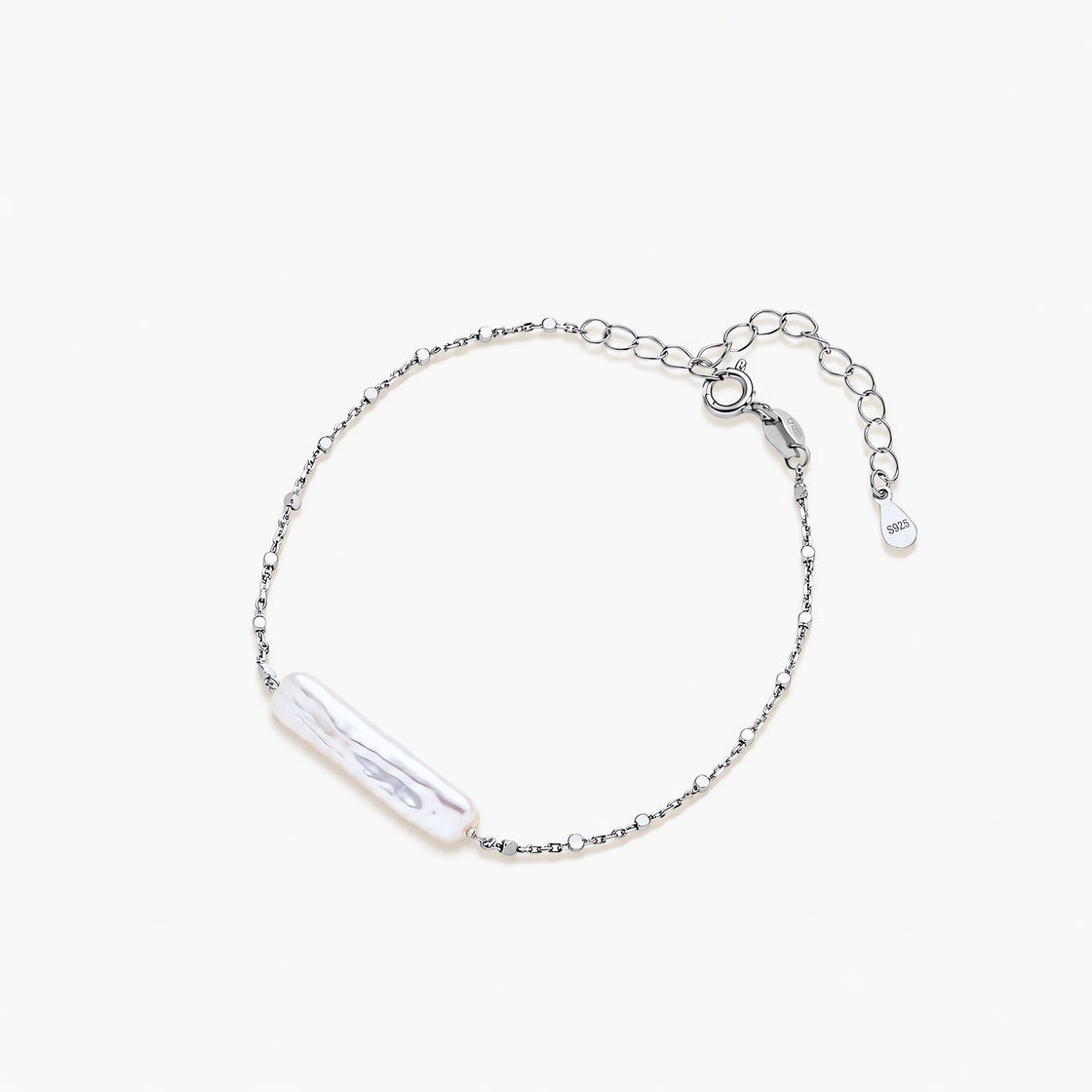 Minimalist bracelet with iridescent baroque pearl on rhodium-plated sterling silver chain against cream background