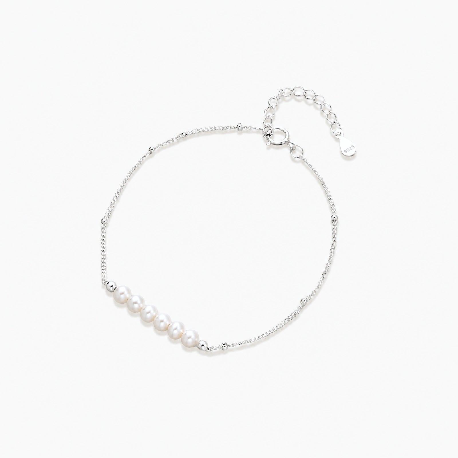 Delicate rhodium-plated silver chain bracelet with row of small baroque pearls centered on white background.