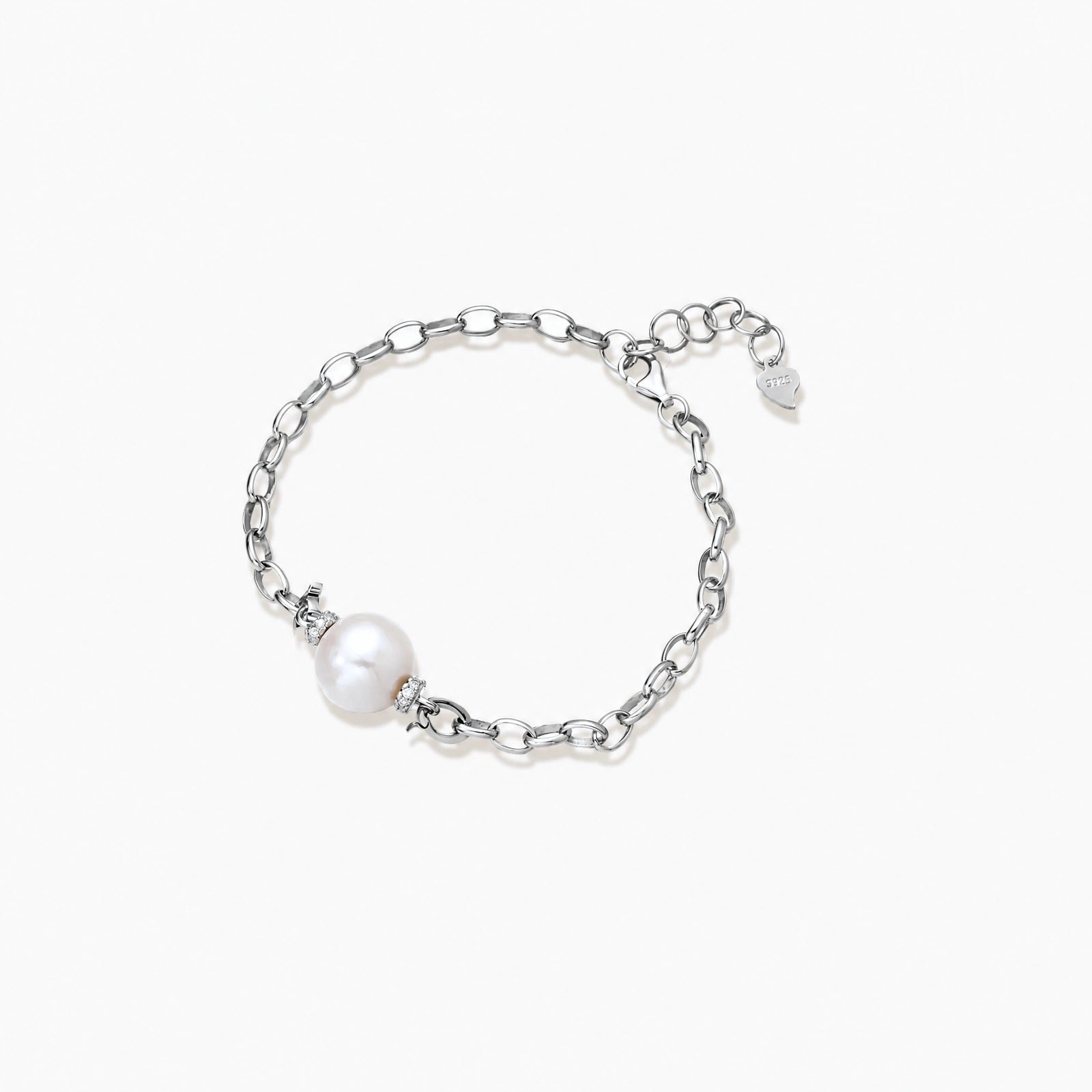Rhodium-plated silver chain bracelet with single white freshwater pearl and heart charm clasp on cream background