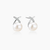 Rhodium-plated silver stud earrings with sparkling X design above lustrous round freshwater pearls on white background.