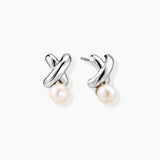 Rhodium-plated silver earrings with twisted X design and freshwater pearl drops on beige background