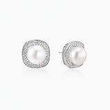 Rhodium-plated sterling silver stud earrings with round freshwater pearls surrounded by geometric crystal halos on cream background.