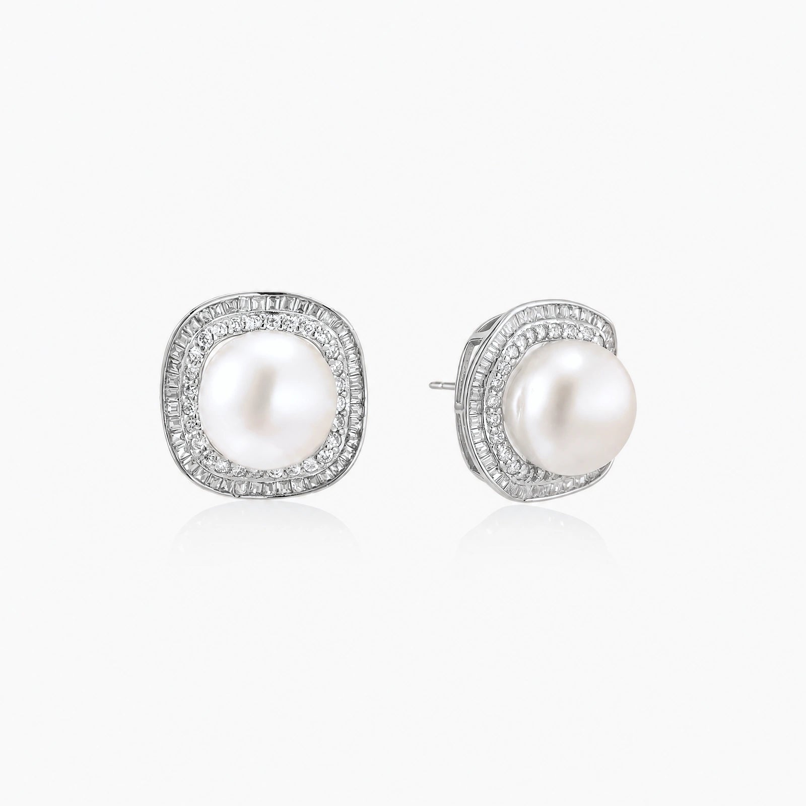 Rhodium-plated sterling silver stud earrings with round freshwater pearls surrounded by geometric crystal halos on cream background.
