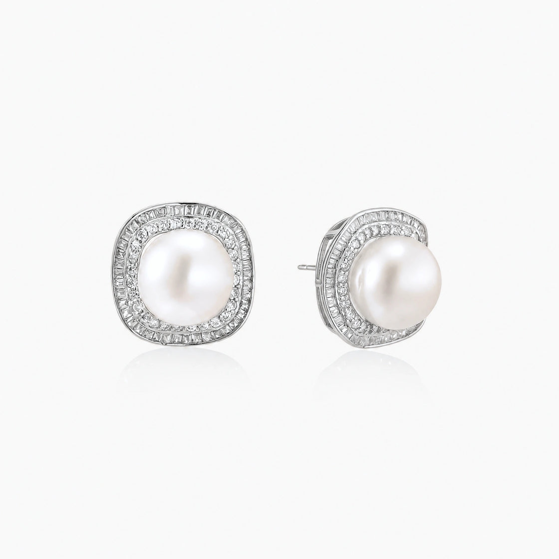 Rhodium-plated sterling silver stud earrings with round freshwater pearls surrounded by geometric crystal halos on cream background.