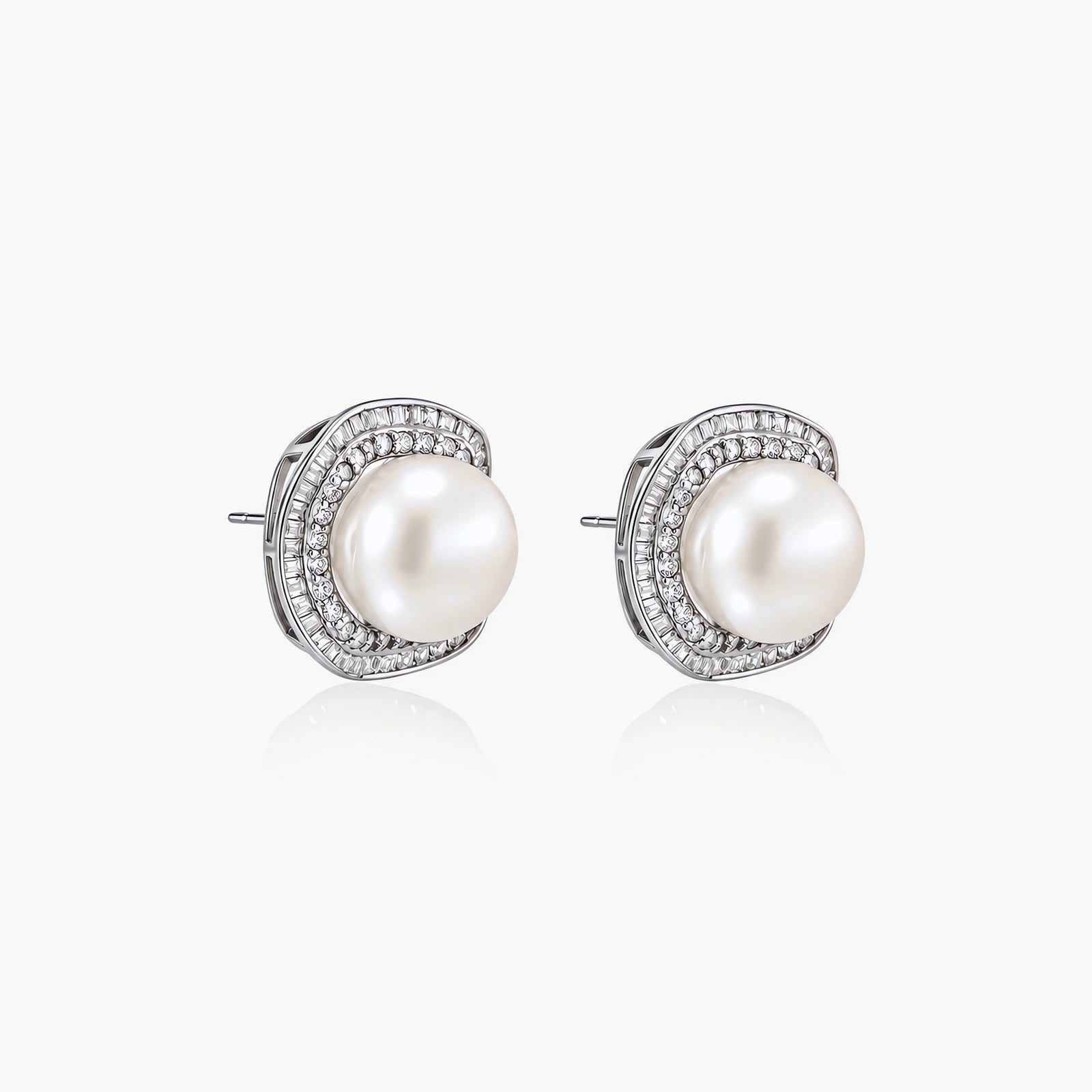 Rhodium-plated sterling silver stud earrings with round freshwater pearls surrounded by geometric crystal halos on cream background.