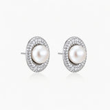 Elegant stud earrings with cream freshwater pearls surrounded by sparkly pavé crystals on rhodium-plated silver setting