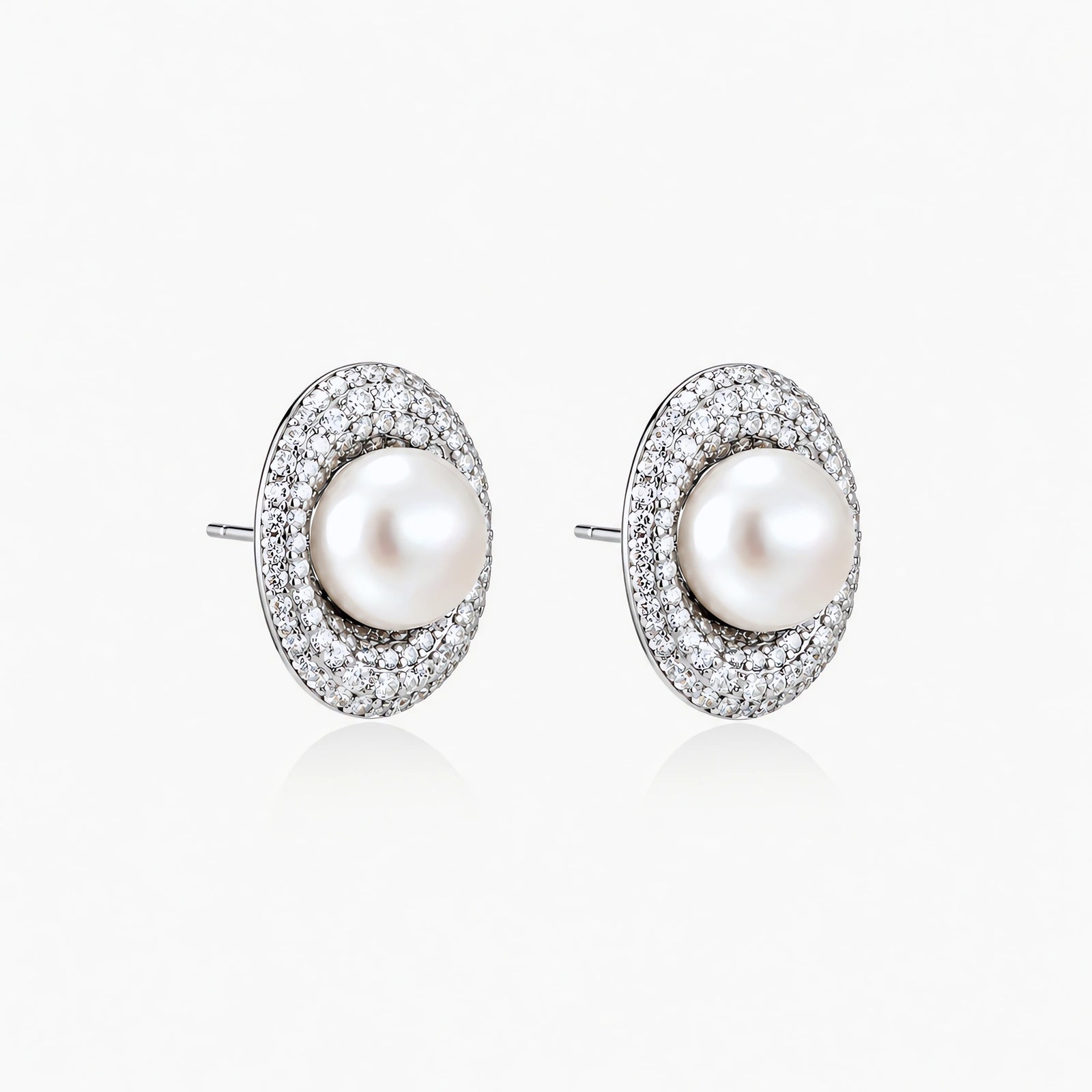 Elegant stud earrings with cream freshwater pearls surrounded by sparkly pavé crystals on rhodium-plated silver setting