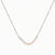 Delicate sterling silver chain necklace with small freshwater pearls arranged in a curved smile arc on cream background.