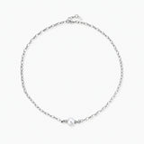 Dainty rhodium-plated silver chain necklace with centered 10mm freshwater pearl and crystal accents on cream background