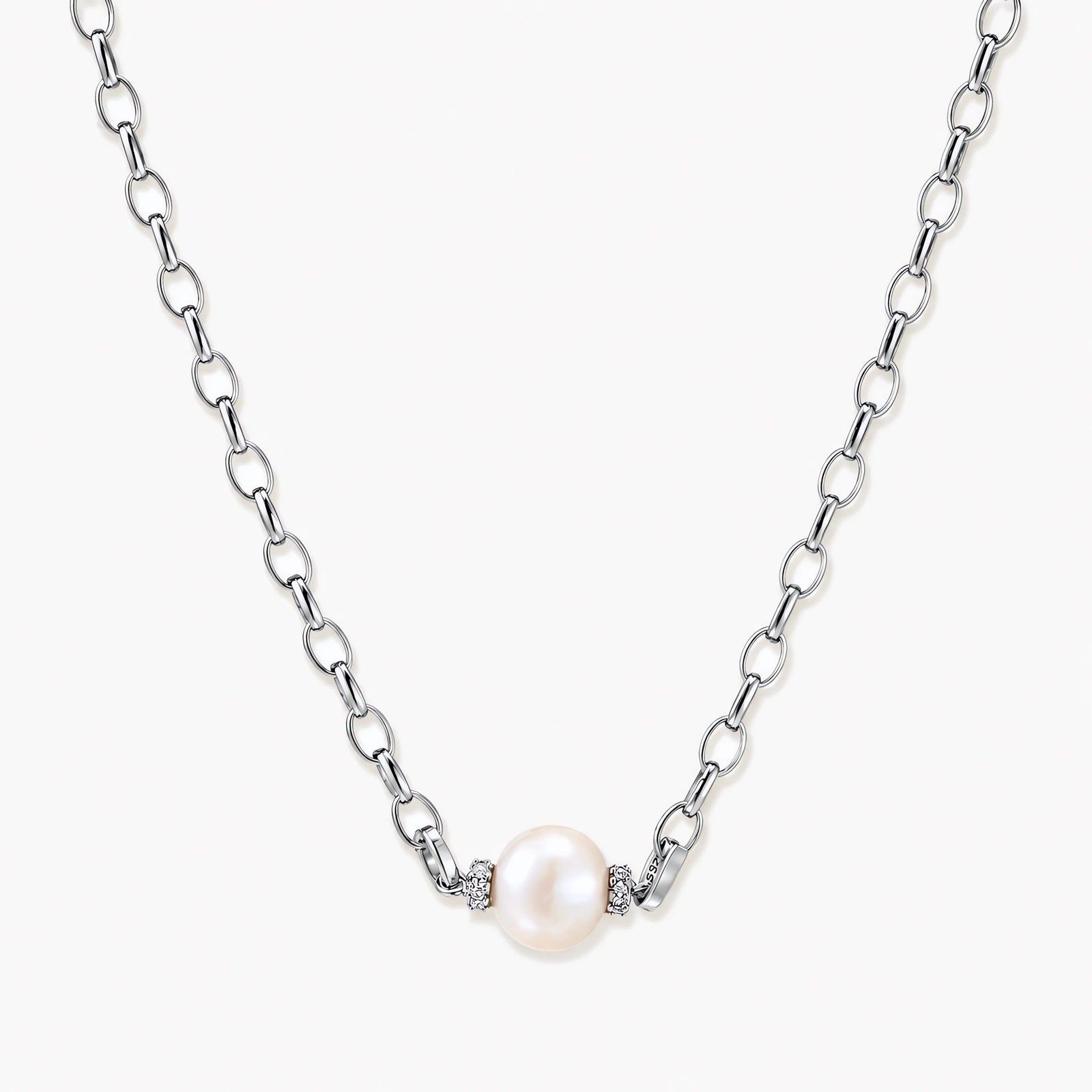 Dainty rhodium-plated silver chain necklace with centered 10mm freshwater pearl and crystal accents on cream background