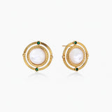 Circular gold stud earrings with iridescent mother-of-pearl center and green zirconia accents on cream background.