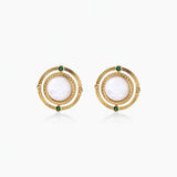 Circular gold stud earrings with iridescent mother-of-pearl center and green zirconia accents on cream background.