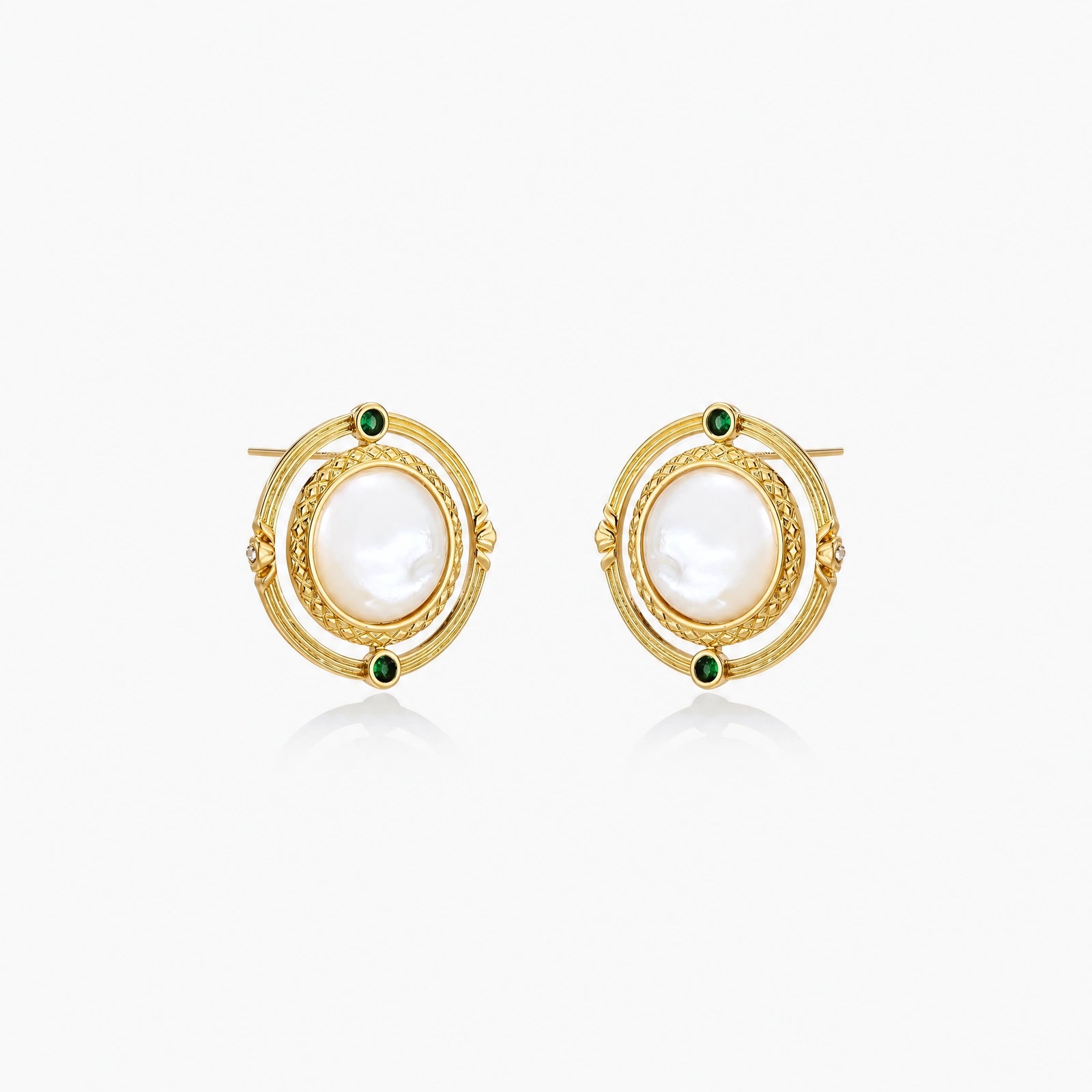 Circular gold stud earrings with iridescent mother-of-pearl center and green zirconia accents on cream background.