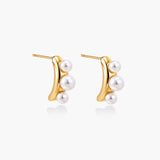 14K gold-plated curved stud earrings with three white freshwater pearls aligned vertically on cream background
