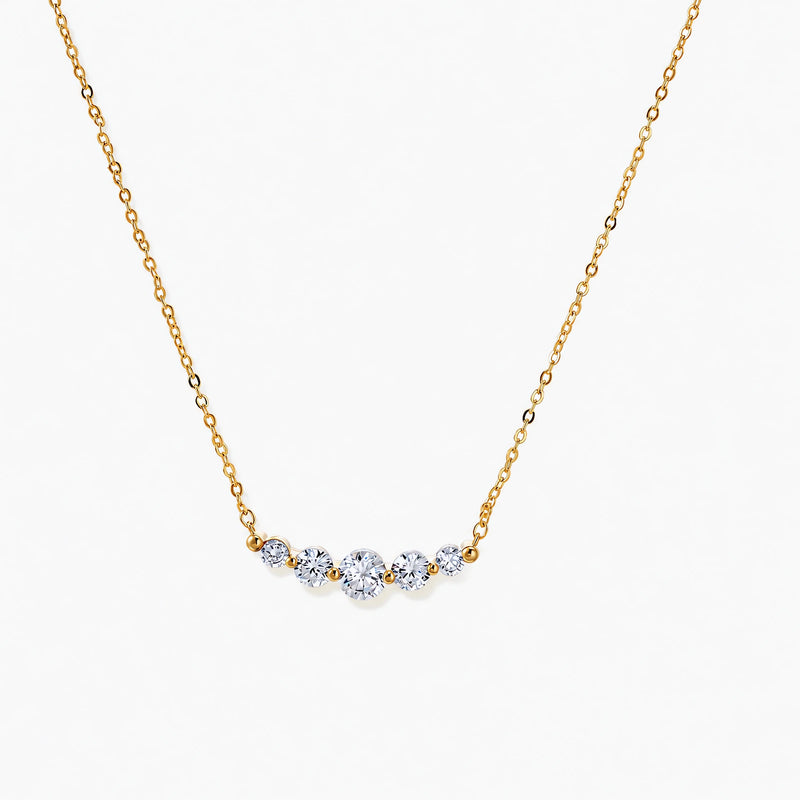 Delicate 14K gold-plated necklace with five graduated zirconia stones arranged in a curved arc on fine chain