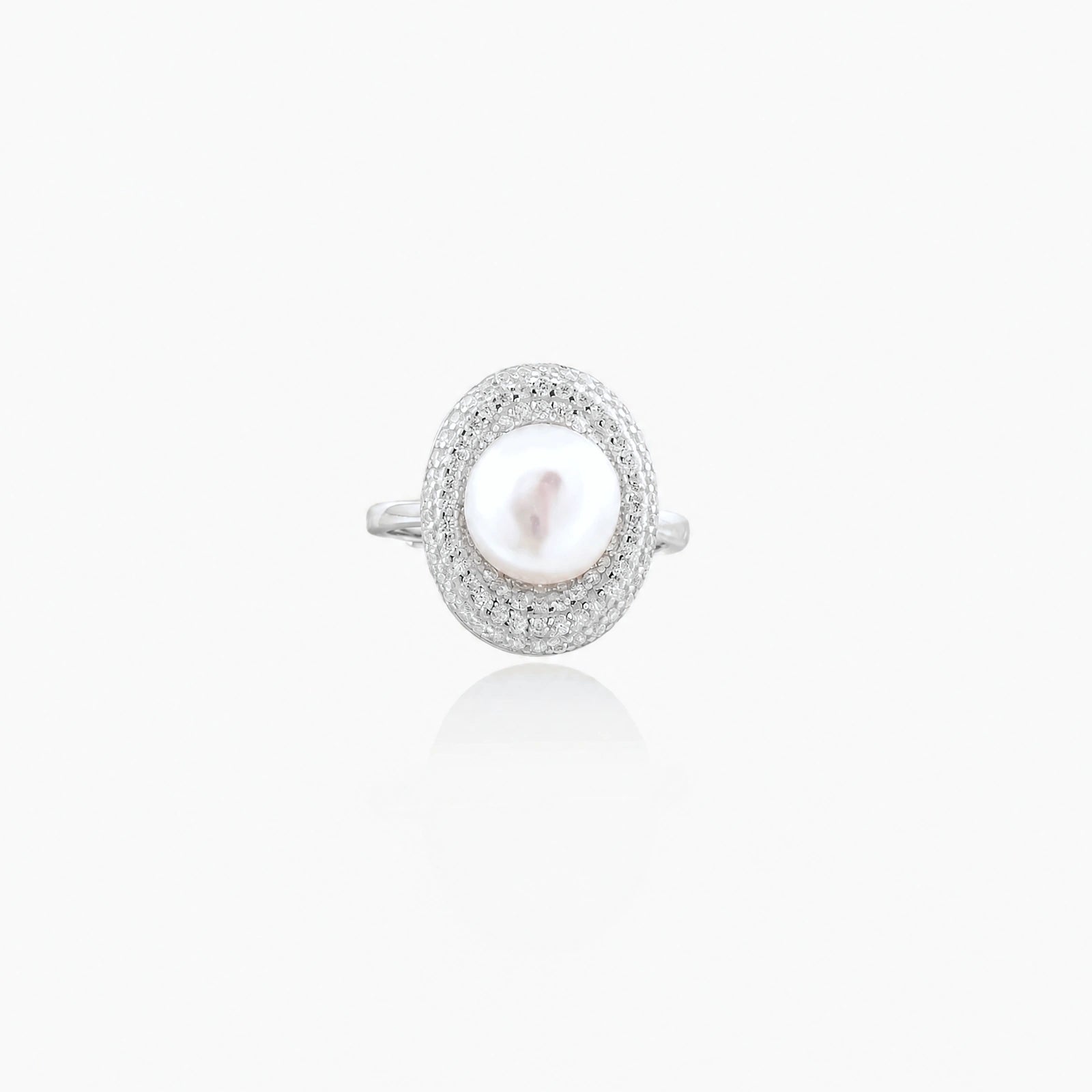Silver ring with lustrous white pearl center surrounded by sparkling crystal halo on light background.