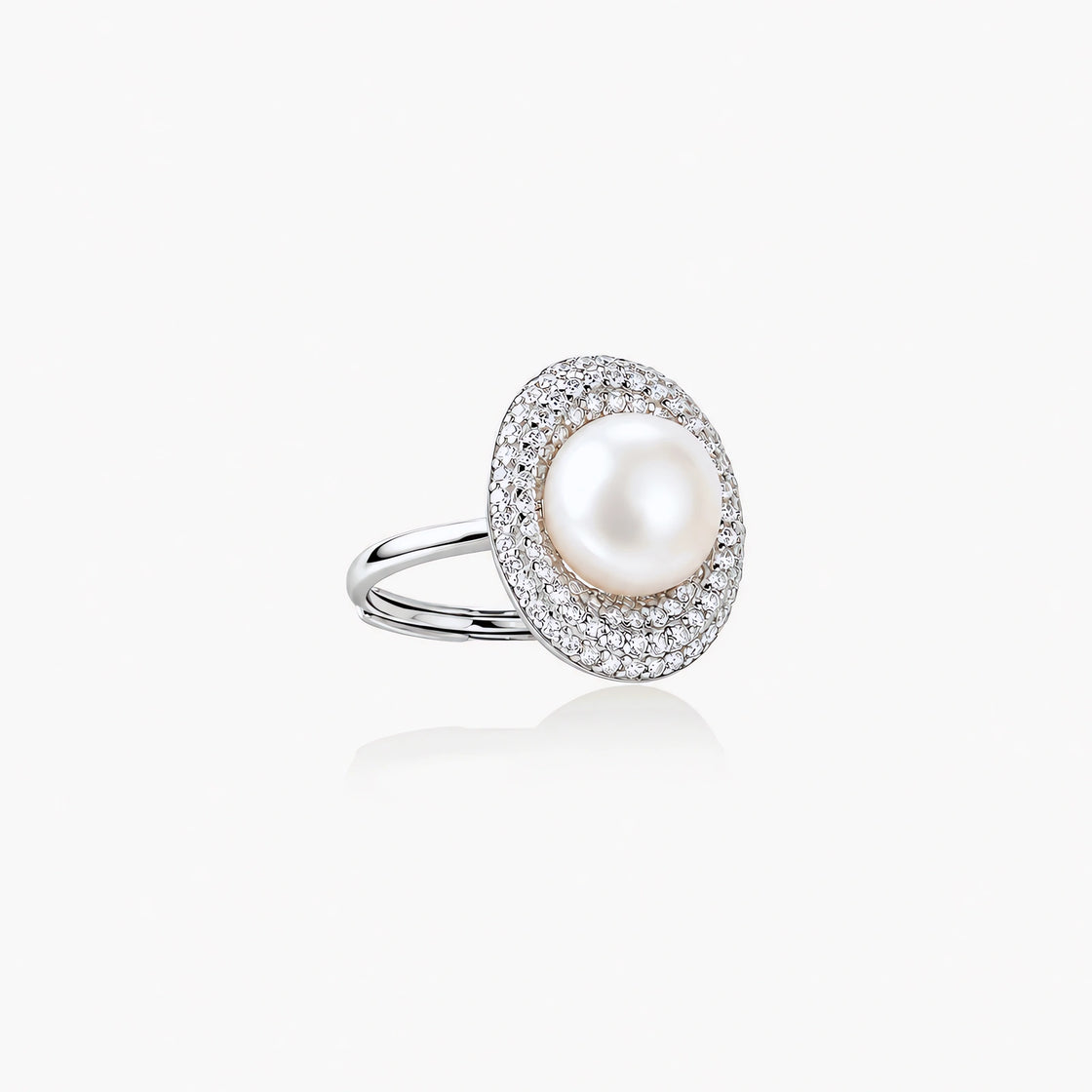 Silver ring with lustrous white pearl center surrounded by sparkling crystal halo on light background.