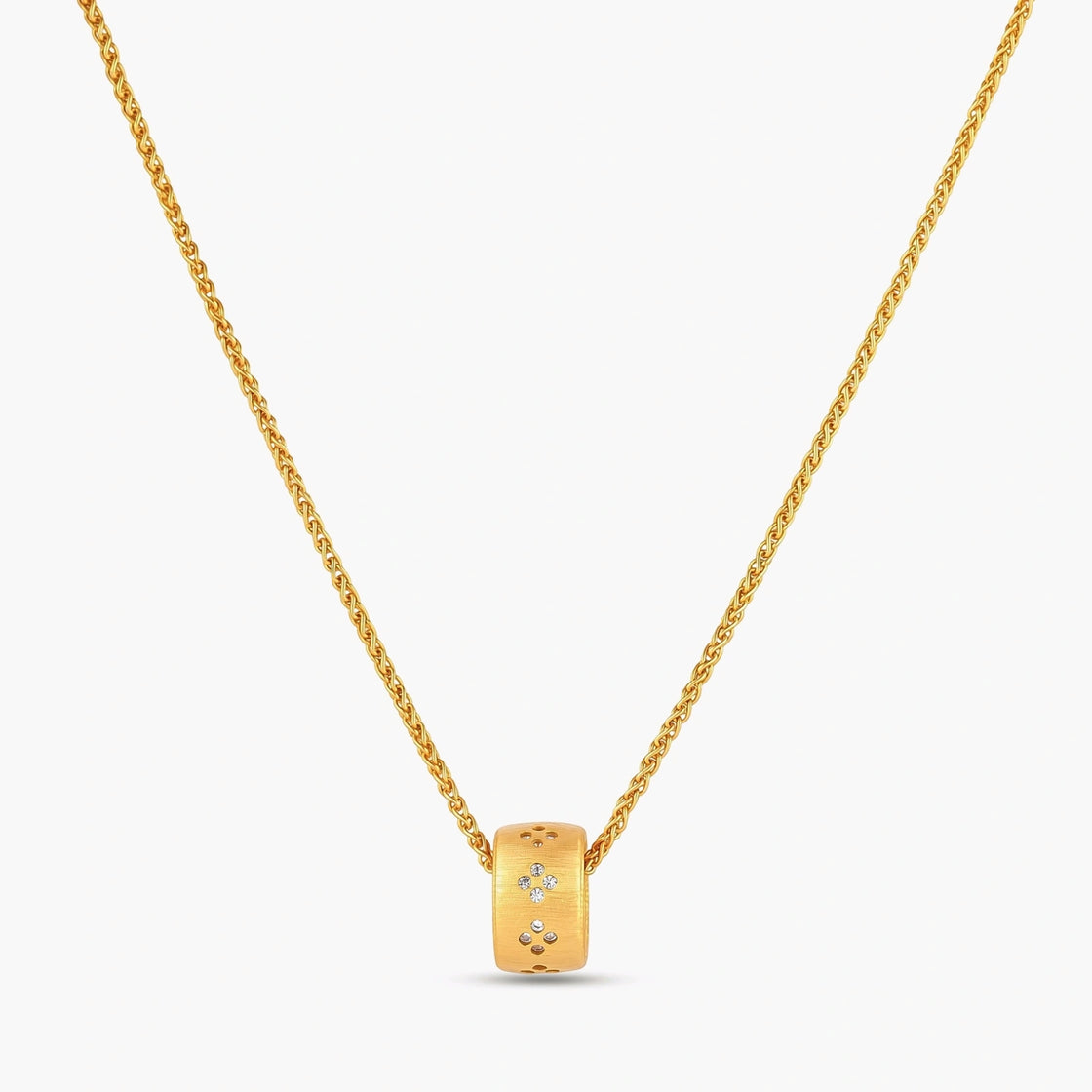 Gold-plated cylindrical ring pendant with brushed finish and scattered crystal accents on a wheat-link chain, cream background.