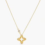 18K gold-plated 925 silver necklace with open four-petal flower pendant, CZ accents, bezel-set stone on chain, white background.