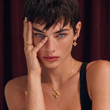 18K gold-plated 925 silver necklace with open four-petal flower pendant, CZ accents, bezel-set stone on chain, white background.