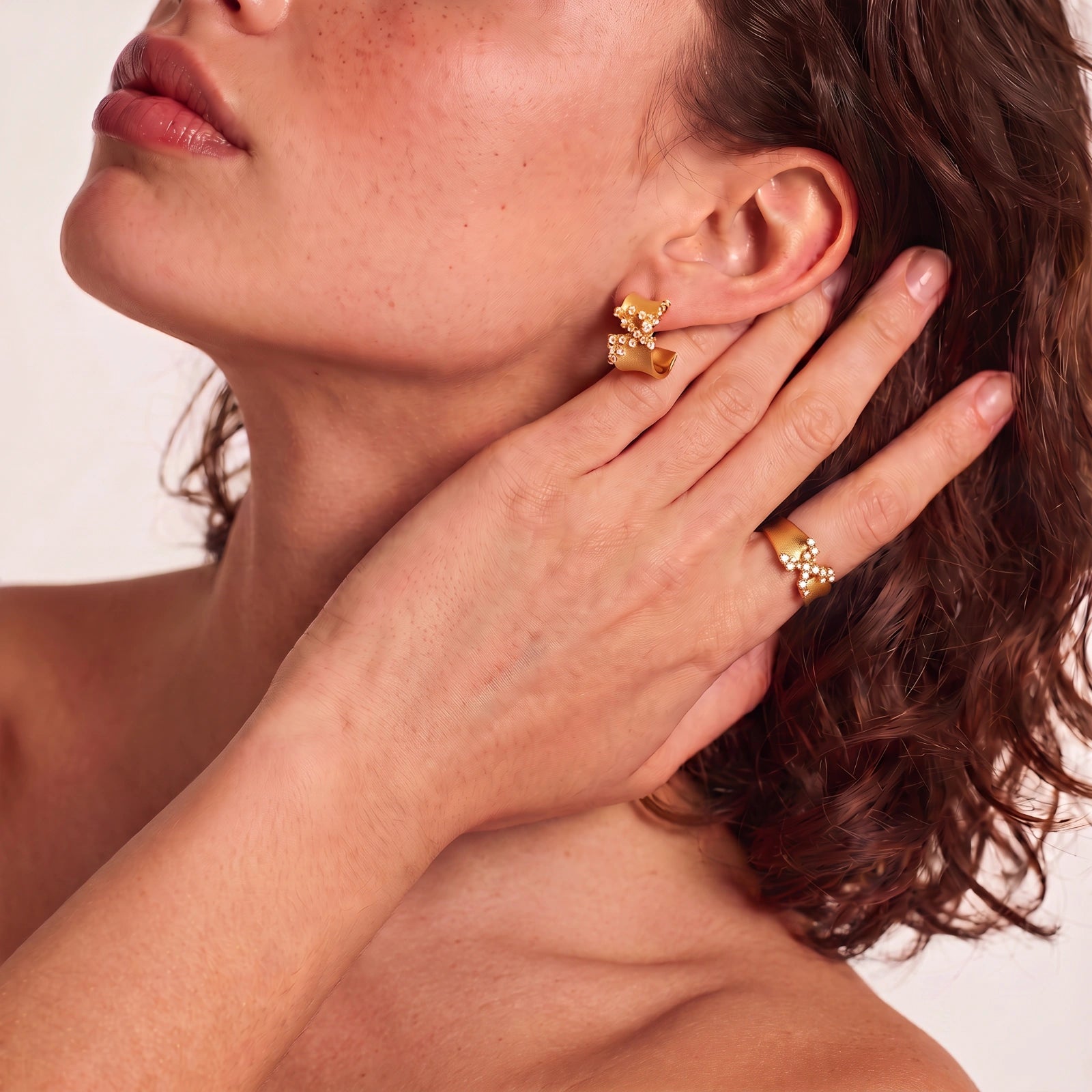 Pair of 18K gold-plated 925 sterling silver C-hoop earrings with brushed finish and scattered cubic zirconia clusters.
