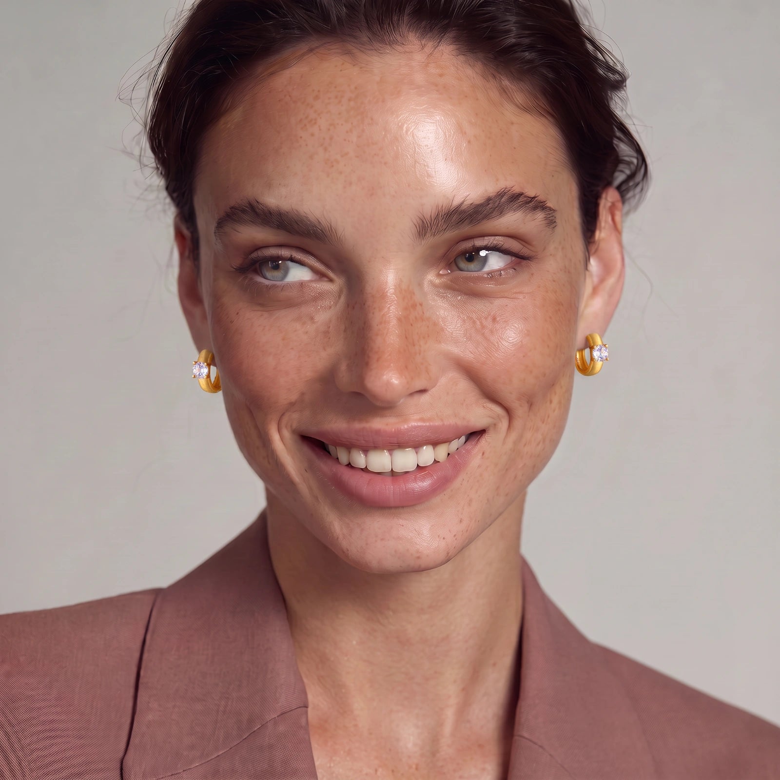 18K gold-plated 925 silver huggie hoops with brushed finish and prong-set round CZ solitaire, stamped S925 inside.