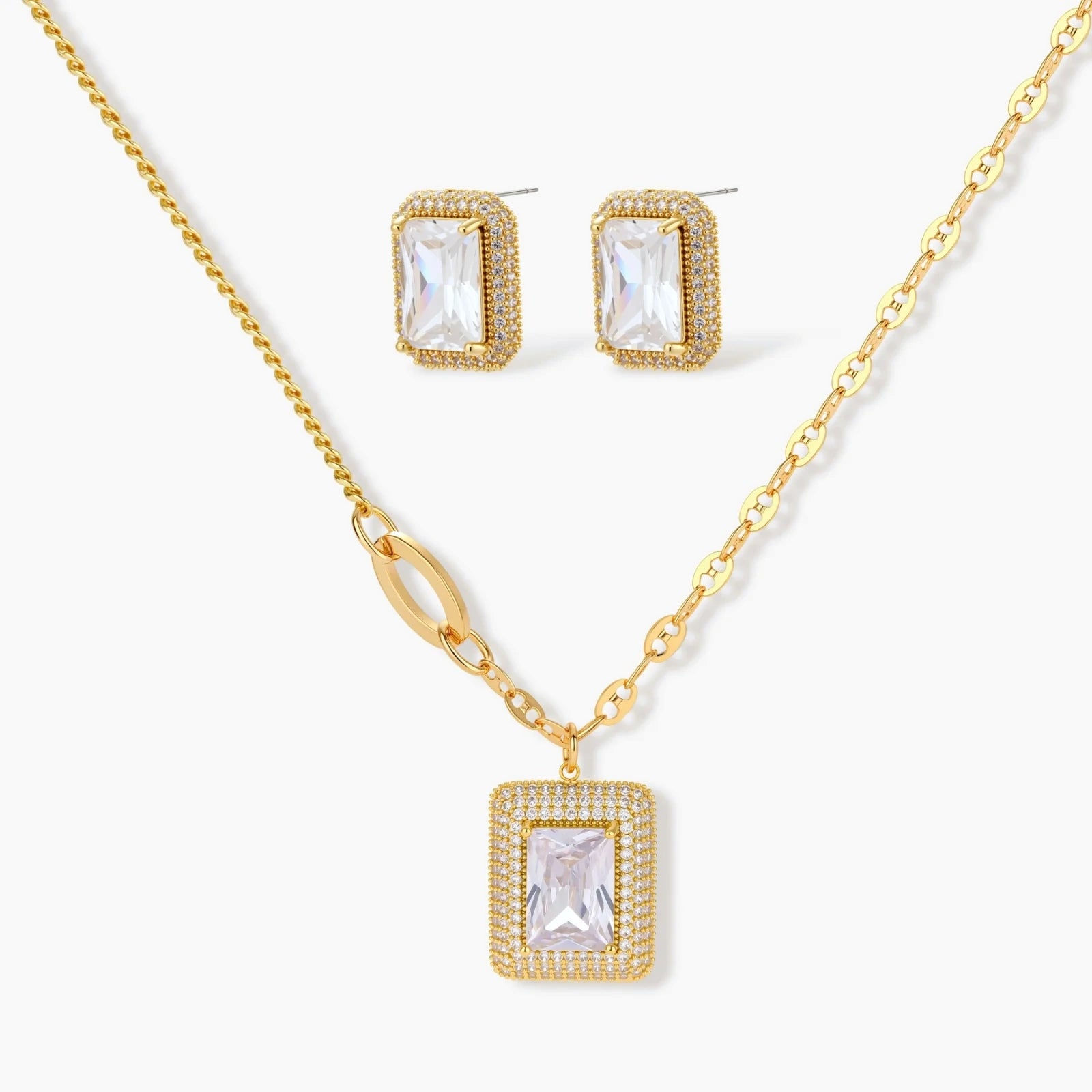 Gold-plated jewelry set with rectangular cubic zirconia stones in pave halo settings on cream background