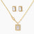 Gold-plated jewelry set with rectangular cubic zirconia stones in pave halo settings on cream background