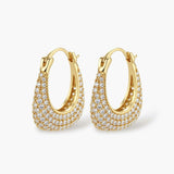 Gold-plated hoop earrings fully covered in sparkling zircon crystals with hinged closure on neutral background