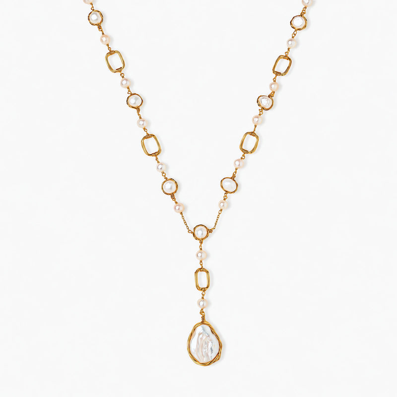 Long gold-plated necklace with alternating freshwater pearls and crystal bezels, featuring a large baroque pearl pendant