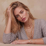 Gold-plated necklace and earring set with circular CZ crystal pendants featuring radial design on cream background