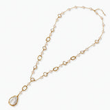 Long gold-plated necklace with alternating freshwater pearls and crystal bezels, featuring a large baroque pearl pendant